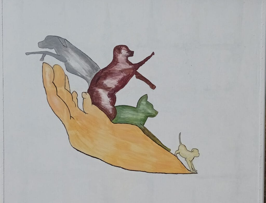 Fresque d'une main tenant des chiens et un chat